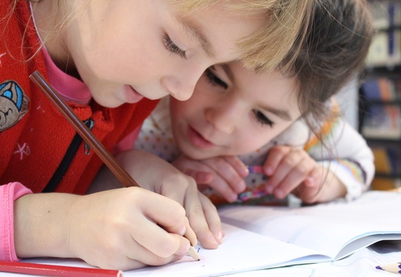 Girls on desk looking at notebook 159823
